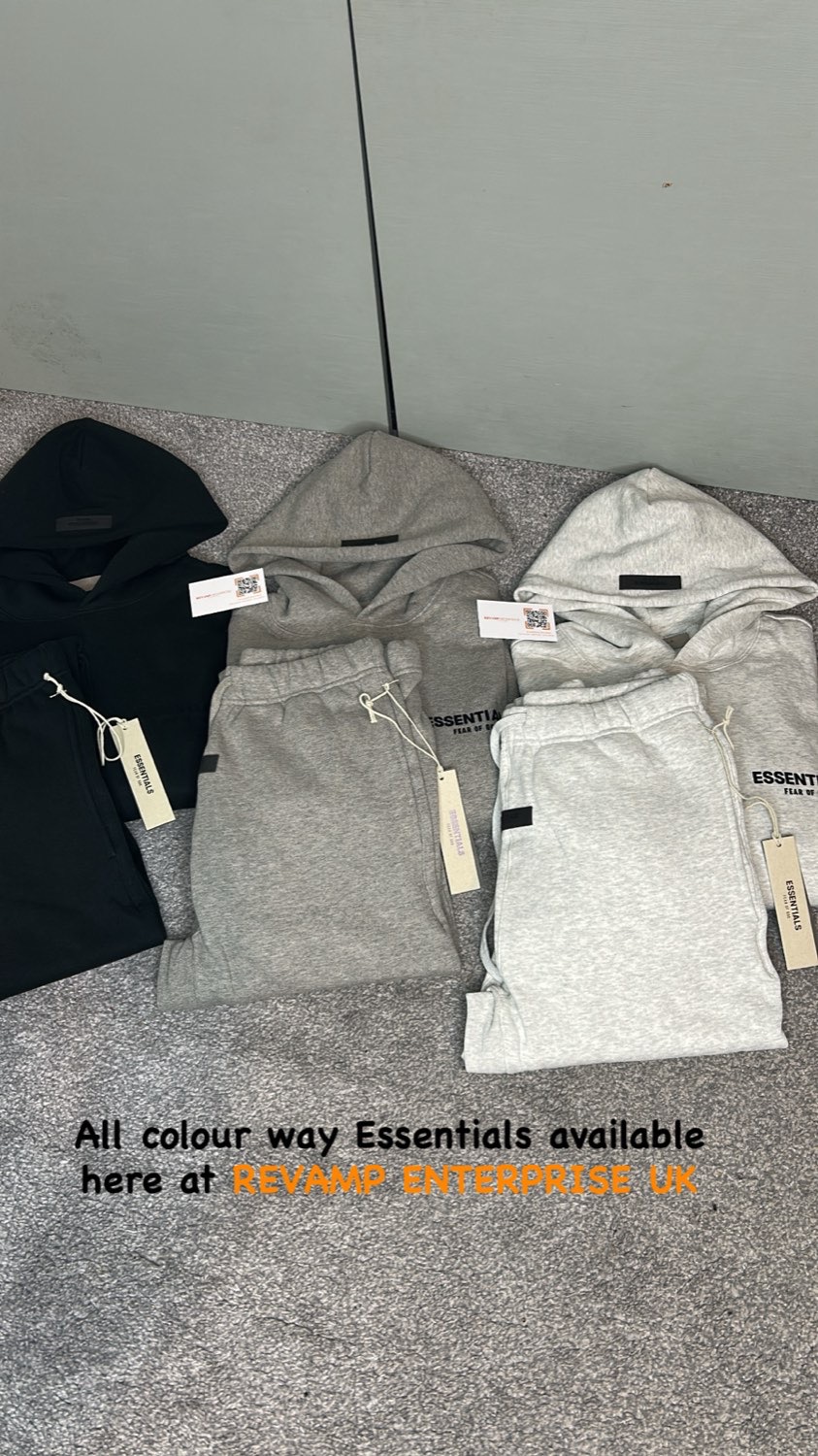 Essentials hoodies and joggers in black, grey and light grey laid out with tags