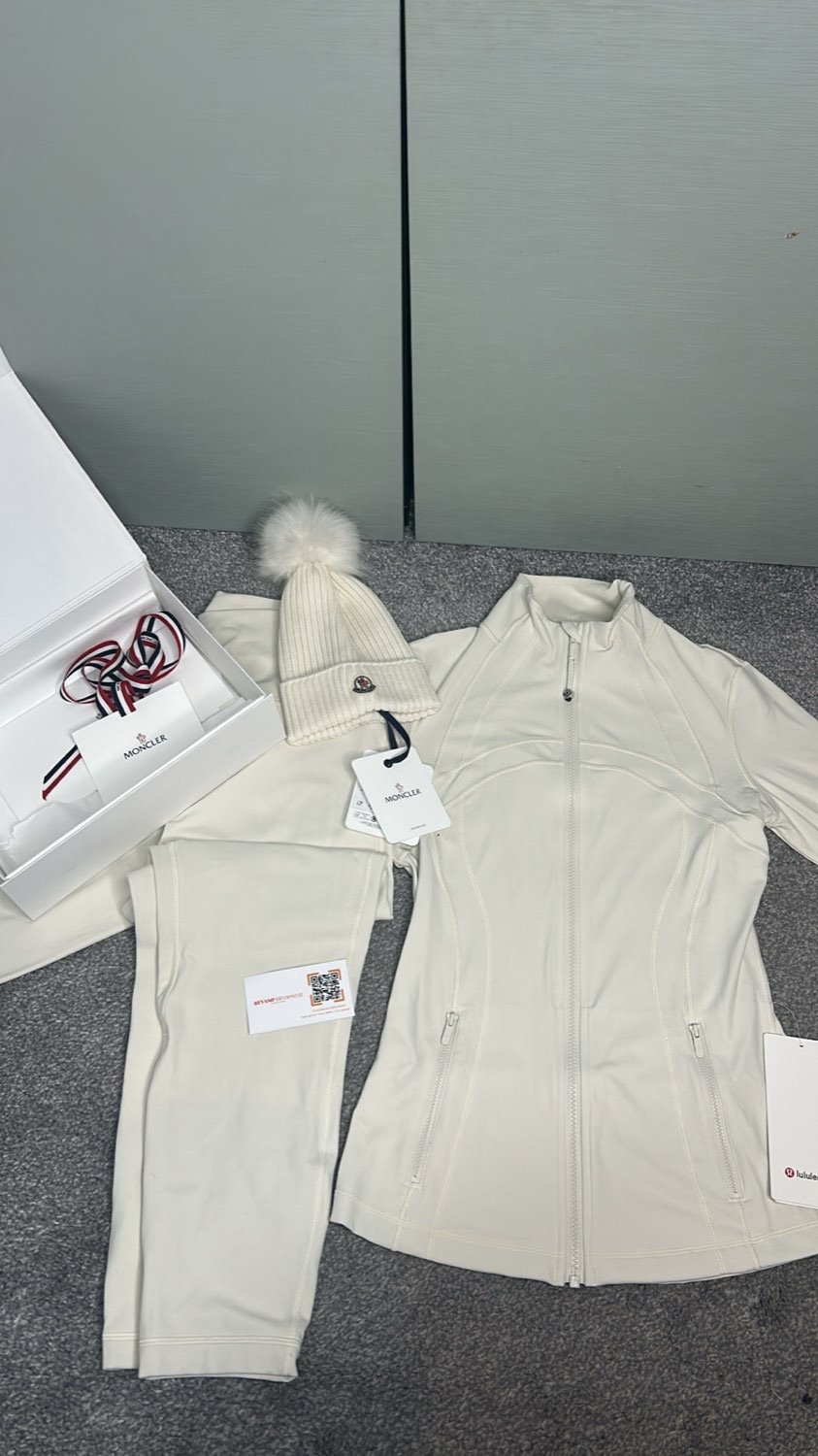 Moncler hat and cream Lululemon jacket and leggings laid out with tags