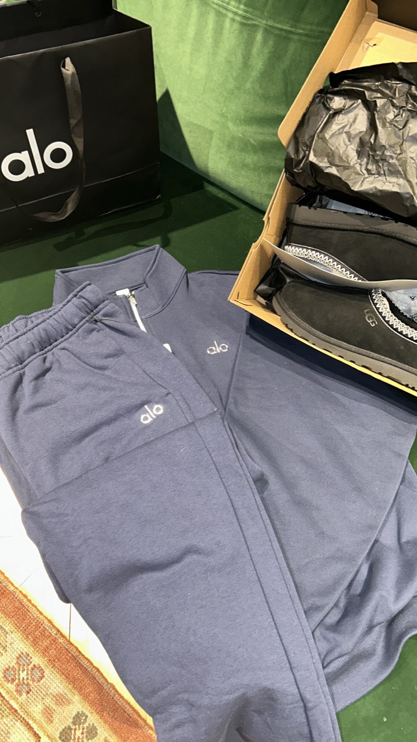 Alo tracksuit laid flat next to its shopping bag